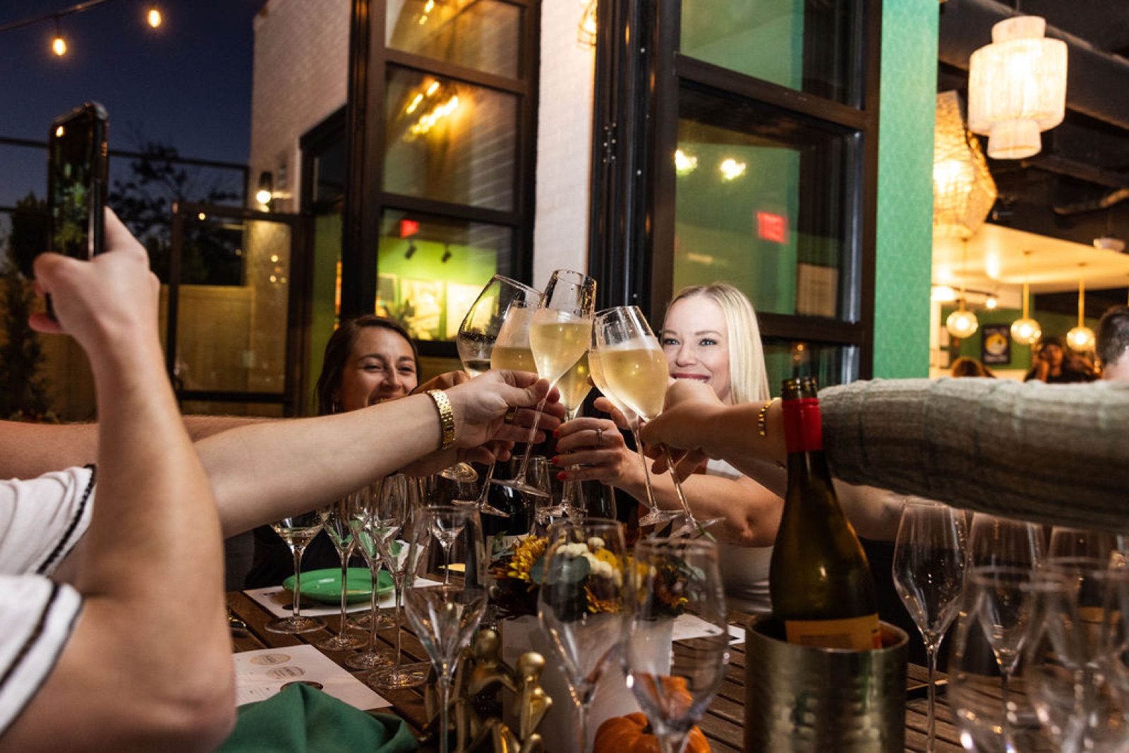 Members raising champagne glasses in a toast at an Offline dinner
